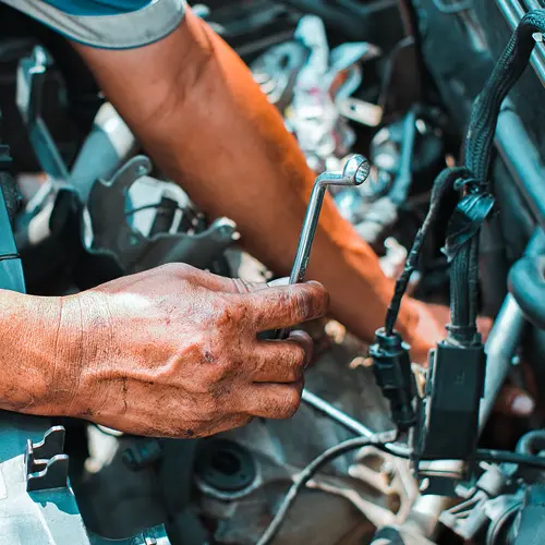 Close-up of mechanic working on truck engine with tools, representing emergency roadside repair and fleet maintenance in Fort Pierce and Fort Lauderdale